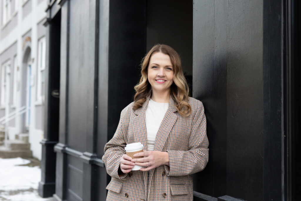 Branding photo of a woman on a downtown street in St John's, Newfoundland and Labrador drinking coffee 